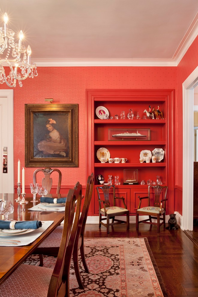 This is an example of a traditional separate dining room in New York with red walls and dark hardwood floors.