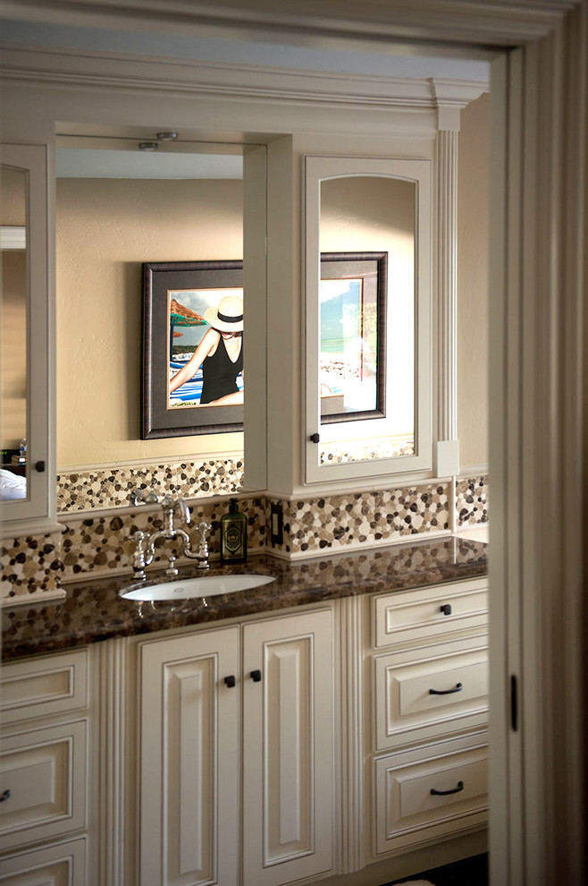 Design ideas for a mid-sized traditional master bathroom in Los Angeles with an undermount sink, raised-panel cabinets, beige cabinets, marble benchtops, a drop-in tub, an alcove shower, a one-piece toilet, brown tile, mosaic tile, beige walls and porcelain floors.