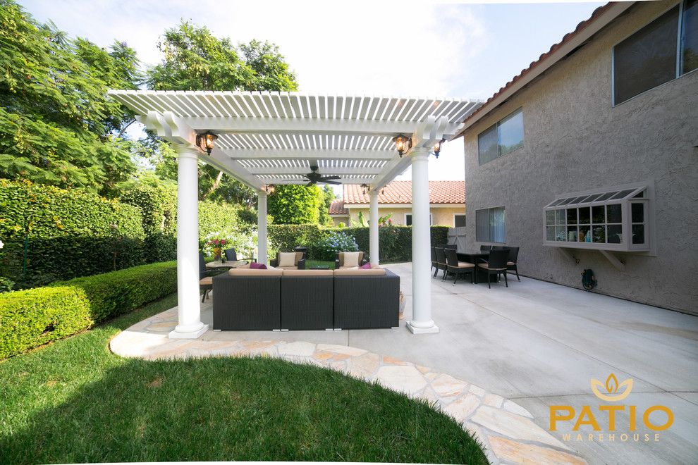 This is an example of a modern backyard patio in Orange County with concrete slab and a pergola.