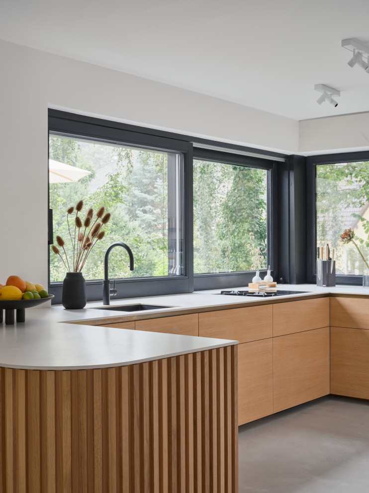 Eat-in kitchen - huge modern u-shaped eat-in kitchen idea in Berlin with flat-panel cabinets, wood countertops, white backsplash, black appliances, no island and gray countertops