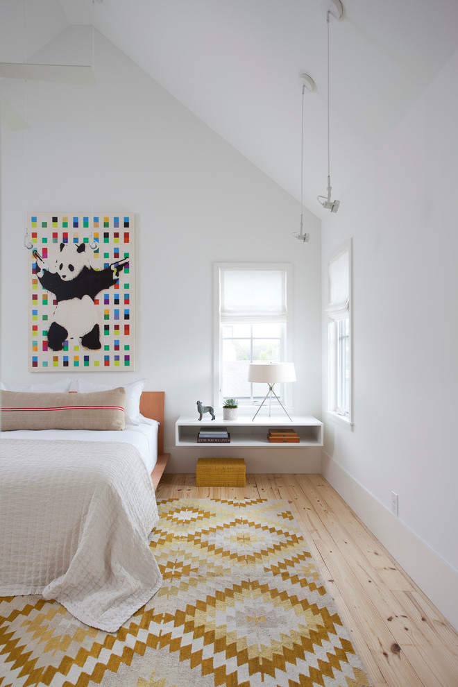 This is an example of a scandinavian master bedroom in Austin with light hardwood floors, no fireplace and white walls.