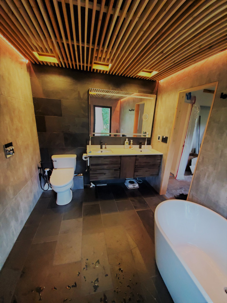 Idée de décoration pour une salle de bain principale design en bois foncé de taille moyenne avec un placard à porte plane, une baignoire indépendante, un espace douche bain, un bidet, un carrelage gris, des carreaux de porcelaine, un mur gris, un sol en ardoise, un lavabo encastré, un plan de toilette en quartz modifié, un sol noir, un plan de toilette blanc, meuble double vasque, meuble-lavabo suspendu et un plafond en bois.
