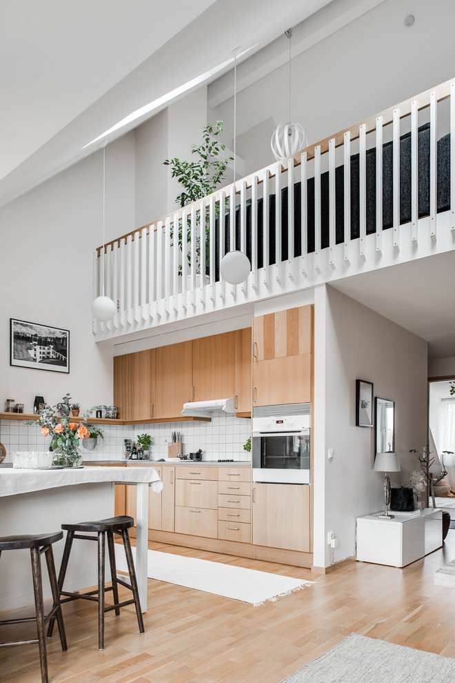 Mid-sized scandinavian single-wall kitchen in Gothenburg with beaded inset cabinets, light wood cabinets, stainless steel benchtops, stainless steel appliances, light hardwood floors and no island.