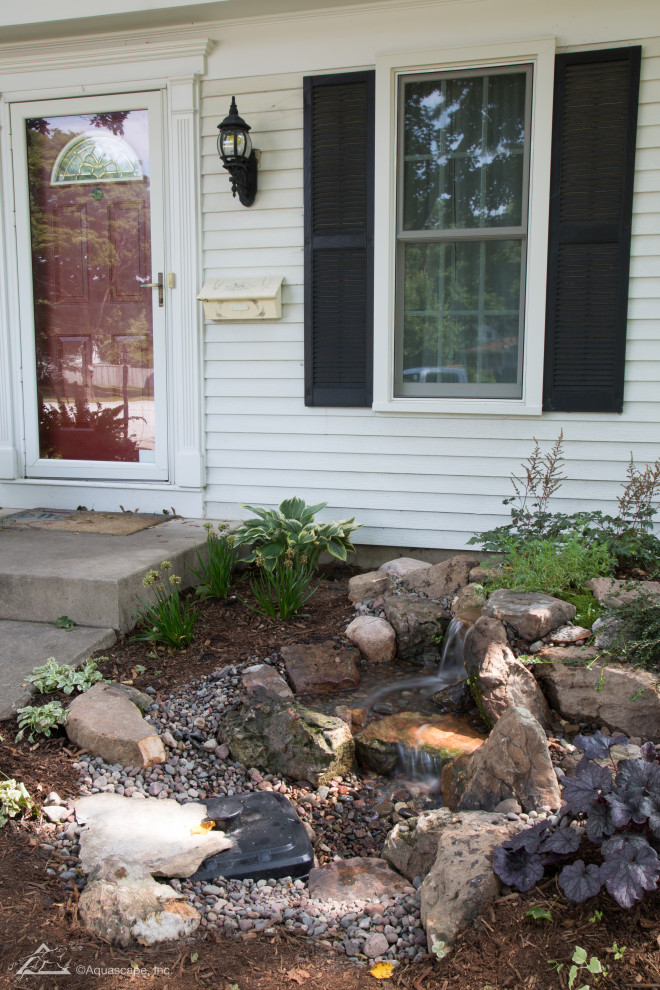 Inspiration for a mid-sized front yard partial sun garden for summer in Charlotte with with waterfall and river rock.