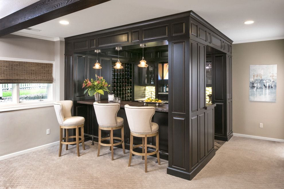 Inspiration for a large traditional u-shaped seated home bar in Minneapolis with carpet, grey floor, an undermount sink, raised-panel cabinets, black cabinets, wood benchtops and multi-coloured splashback.