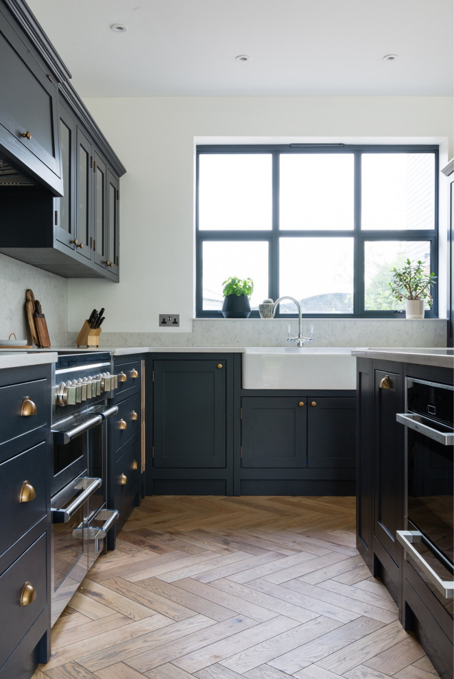 Nordische Wohnküche mit Schrankfronten im Shaker-Stil, grauen Schränken, Quarzit-Arbeitsplatte, braunem Holzboden, Kücheninsel und weißer Arbeitsplatte in Hertfordshire