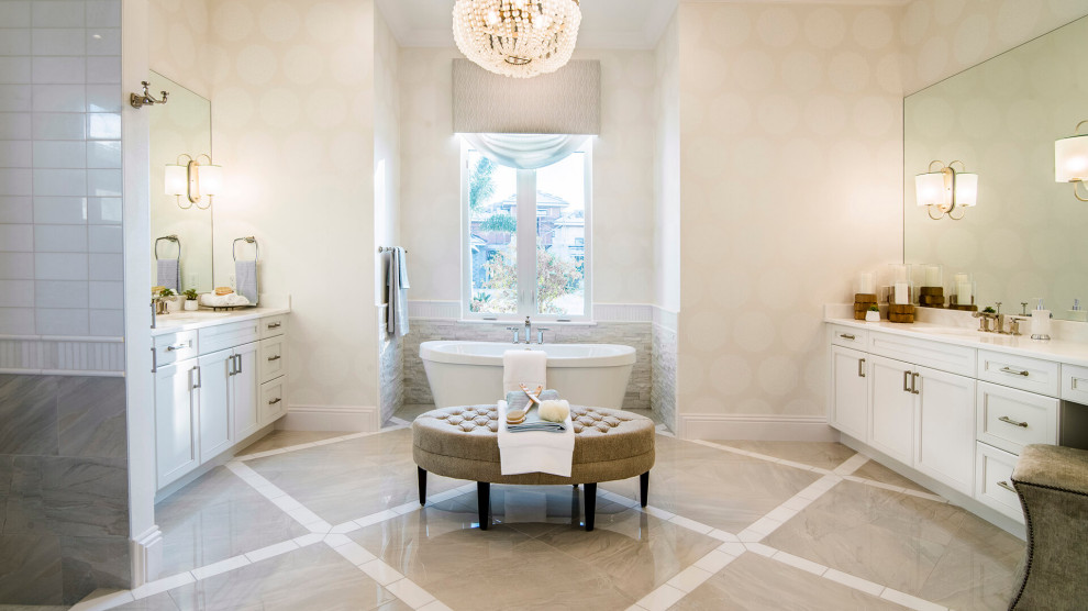 Large beach style master bathroom with recessed-panel cabinets, white cabinets, a freestanding tub, an open shower, a one-piece toilet, mirror tile, beige walls, marble floors, a drop-in sink, granite benchtops, beige floor, an open shower and white benchtops.
