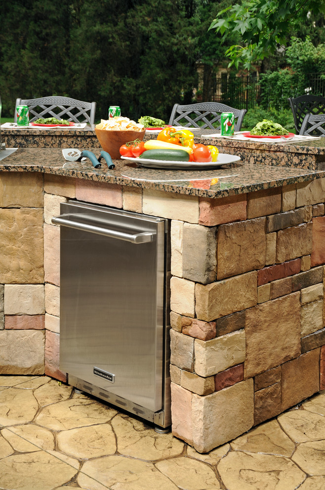 Large elegant backyard stamped concrete patio kitchen photo with no cover
