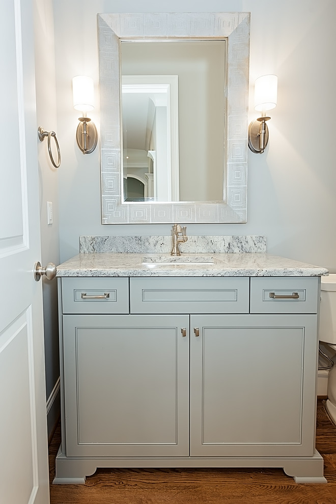 Photo of a traditional powder room in Other with an undermount sink, recessed-panel cabinets, granite benchtops and blue cabinets.