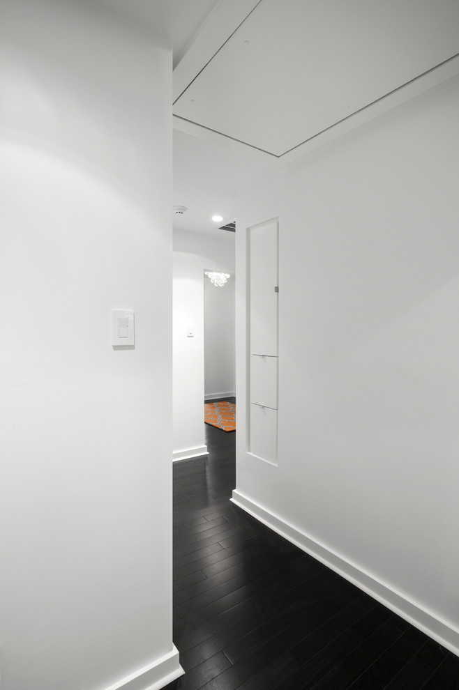 Mid-sized midcentury hallway in Houston with white walls, dark hardwood floors and brown floor.