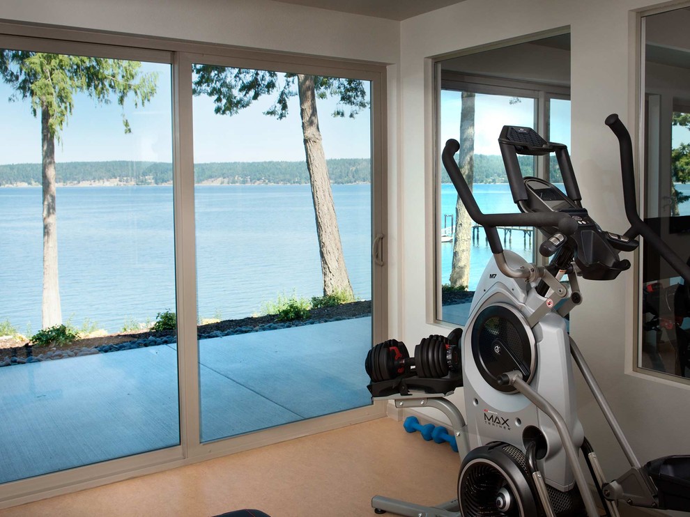 Mid-sized beach style multipurpose gym in Seattle with beige walls and brown floor.