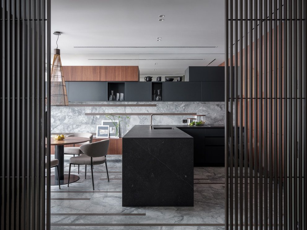 This is an example of a contemporary u-shaped eat-in kitchen in Moscow with flat-panel cabinets, black cabinets, grey splashback, stone slab splashback, a peninsula, grey floor, black benchtop and an undermount sink.