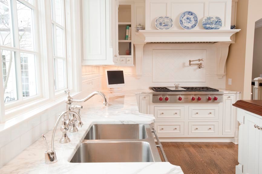 This is an example of a traditional galley eat-in kitchen in Indianapolis with a farmhouse sink, flat-panel cabinets, white cabinets, marble benchtops, white splashback, subway tile splashback, stainless steel appliances, with island and white benchtop.
