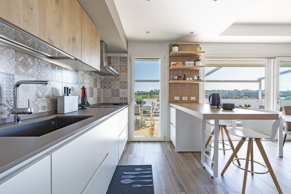 Design ideas for a mid-sized contemporary galley eat-in kitchen in Rome with an undermount sink, flat-panel cabinets, white cabinets, wood benchtops, grey splashback, mosaic tile splashback, panelled appliances, medium hardwood floors, a peninsula, beige floor and beige benchtop.