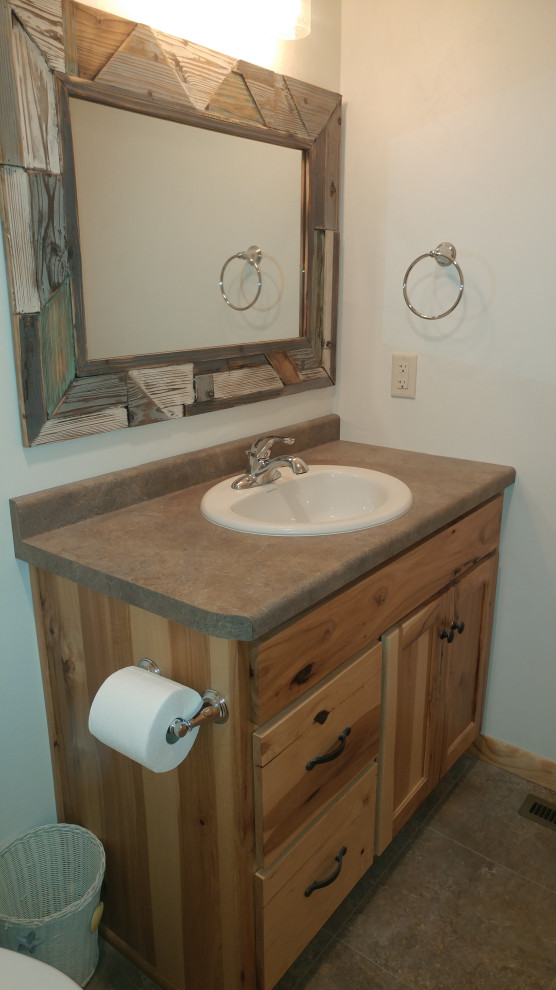 This is an example of a mid-sized country master bathroom in Other with flat-panel cabinets, light wood cabinets, white walls, ceramic floors, a drop-in sink, laminate benchtops, multi-coloured floor, multi-coloured benchtops, an enclosed toilet, a single vanity and a built-in vanity.