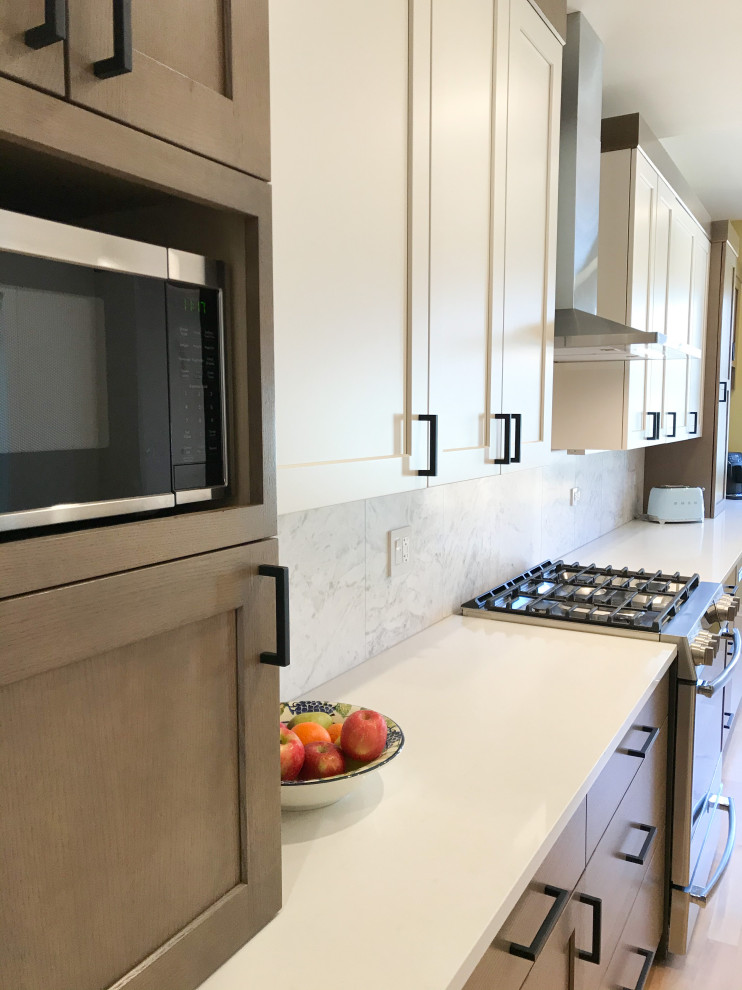 Inspiration for a large transitional l-shaped eat-in kitchen remodel in Chicago with a double-bowl sink, shaker cabinets, white cabinets, quartz countertops, multicolored backsplash, porcelain backsplash, stainless steel appliances, an island and white countertops