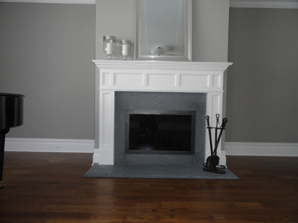Photo of a mid-sized traditional open concept family room in New York with a standard fireplace, grey walls, dark hardwood floors and a tile fireplace surround.
