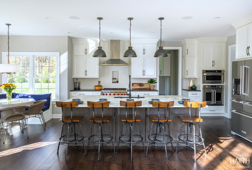 Inspiration for a large transitional galley eat-in kitchen in Philadelphia with an undermount sink, shaker cabinets, white cabinets, quartzite benchtops, white splashback, porcelain splashback, stainless steel appliances, dark hardwood floors, with island, brown floor and multi-coloured benchtop.