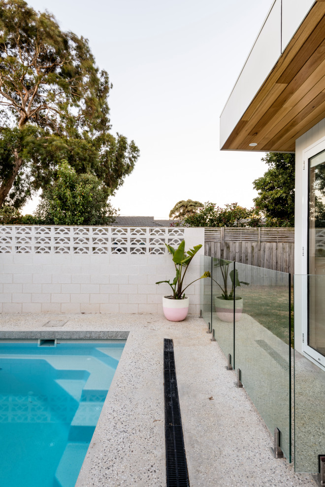 Modelo de piscina retro en patio trasero con paisajismo de piscina