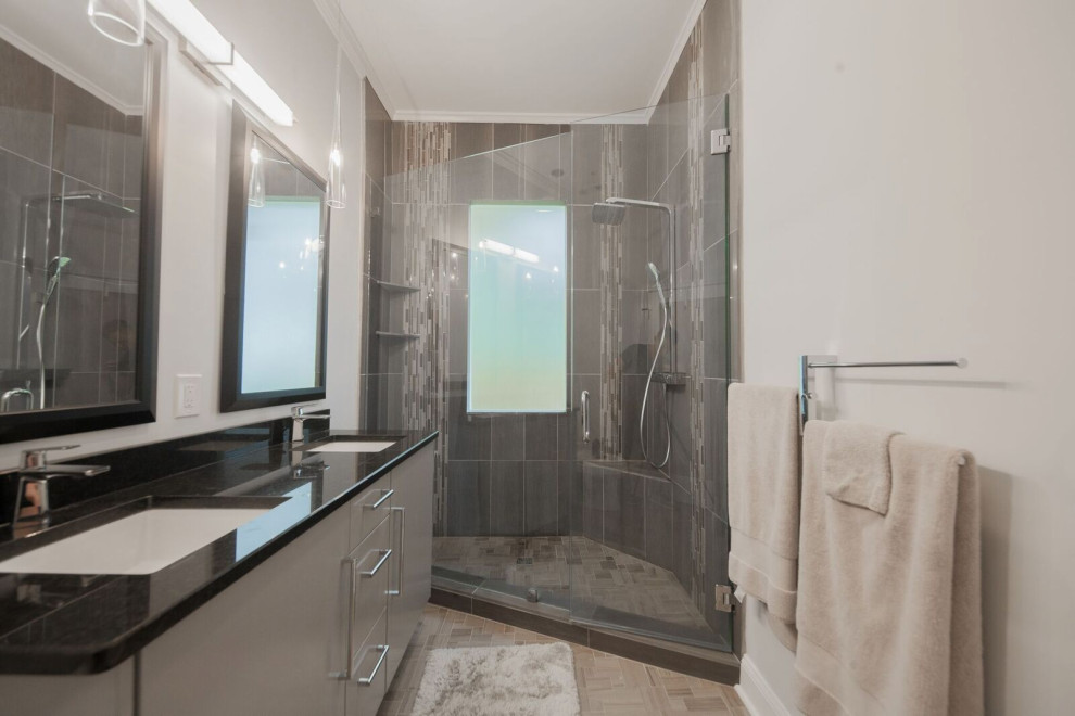 На фото: маленькая главная ванная комната в современном стиле с плоскими фасадами, серыми фасадами, угловым душем, унитазом-моноблоком, серой плиткой, плиткой из травертина, серыми стенами, полом из керамической плитки, врезной раковиной, столешницей из кварцита, серым полом, душем с распашными дверями, черной столешницей, сиденьем для душа, тумбой под две раковины и встроенной тумбой для на участке и в саду с