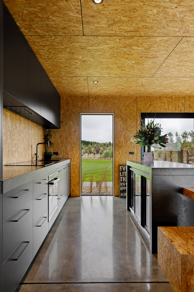 На фото: кухня среднего размера в стиле лофт с черными фасадами, столешницей из бетона, фартуком из дерева и серой столешницей с