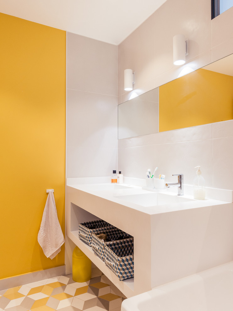 Design ideas for a midcentury master bathroom in Paris with an integrated sink, an undermount tub, a curbless shower, a wall-mount toilet, yellow tile, multi-coloured tile, ceramic tile, grey walls and ceramic floors.