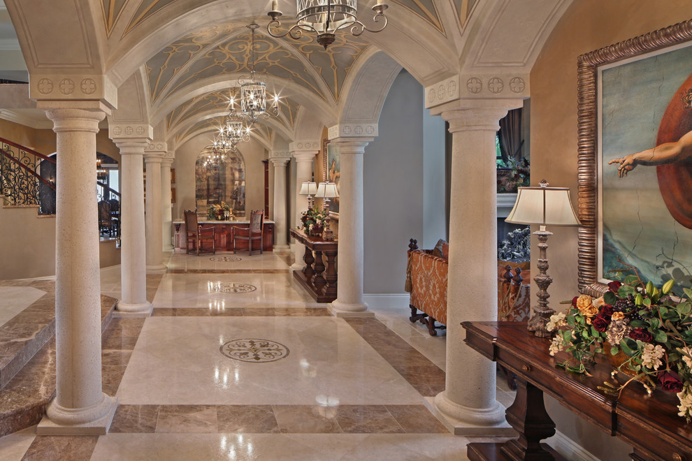 Design ideas for an expansive mediterranean foyer in Miami with beige walls, marble floors and beige floor.