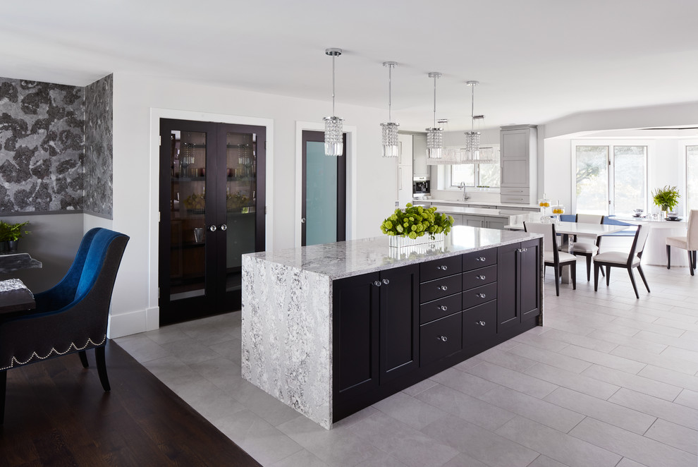 This is an example of an expansive eclectic l-shaped eat-in kitchen in Chicago with quartz benchtops, multiple islands, a drop-in sink, recessed-panel cabinets, dark wood cabinets, white splashback, stainless steel appliances and porcelain floors.