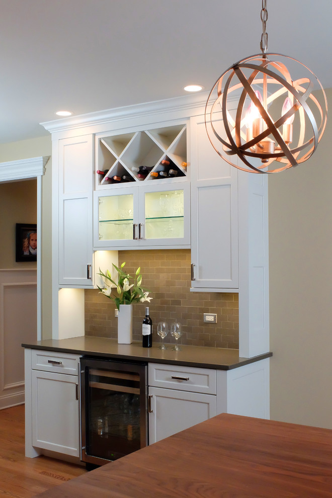 Eat-in kitchen - large transitional u-shaped medium tone wood floor eat-in kitchen idea in Chicago with shaker cabinets, white cabinets, stone tile backsplash, stainless steel appliances, an undermount sink, wood countertops, gray backsplash and an island