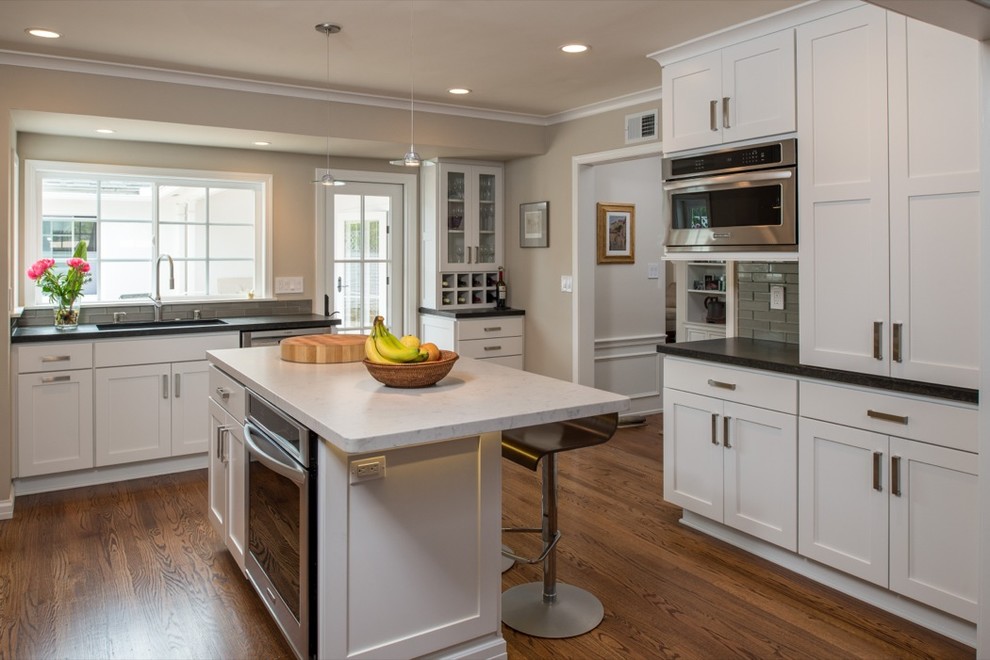 Inspiration for a large contemporary u-shaped open plan kitchen in San Diego with a drop-in sink, recessed-panel cabinets, white cabinets, marble benchtops, grey splashback, stainless steel appliances, light hardwood floors and with island.