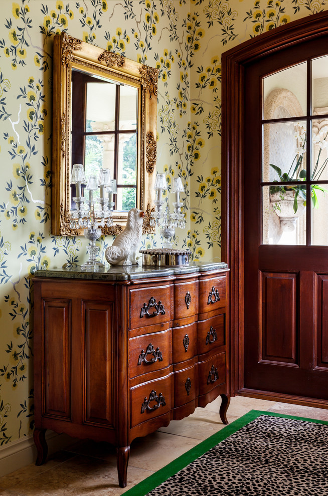 Traditional foyer in Miami with yellow walls and a dark wood front door.