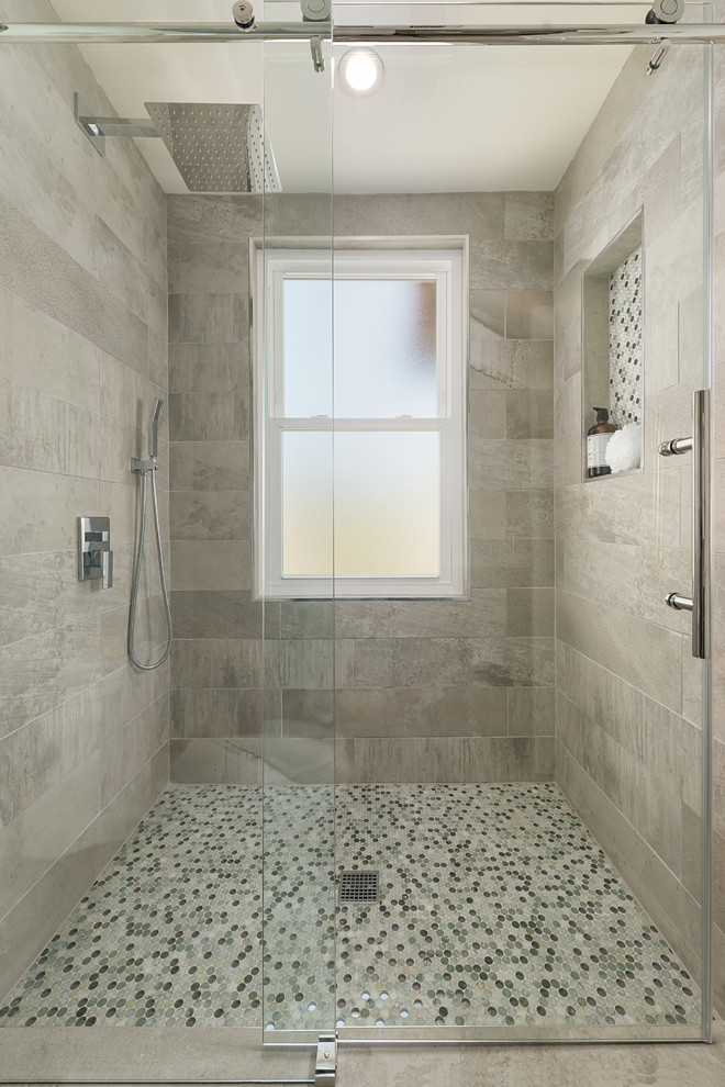 Photo of a mid-sized contemporary master bathroom in San Francisco with flat-panel cabinets, grey cabinets, an alcove shower, a one-piece toilet, mosaic tile, grey walls, ceramic floors, an integrated sink, solid surface benchtops, gray tile, grey floor and a sliding shower screen.