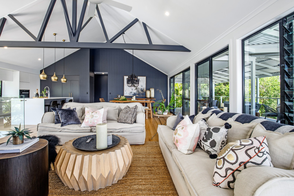 Large beach style open concept living room in Sunshine Coast with white walls, light hardwood floors, a wall-mounted tv and multi-coloured floor.
