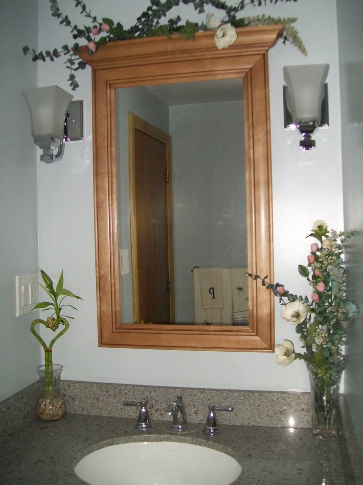 Freestanding bathtub - mid-sized gray tile and ceramic tile ceramic tile freestanding bathtub idea with beaded inset cabinets, brown cabinets, a two-piece toilet, blue walls, an undermount sink and quartz countertops