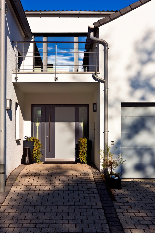 Mid-sized contemporary front door with white walls, concrete floors, a single front door, a gray front door and grey floor.
