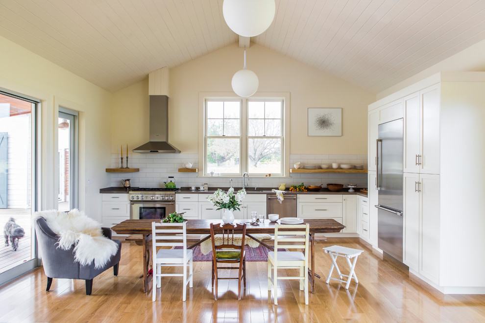 Design ideas for a mid-sized country u-shaped eat-in kitchen in San Francisco with an undermount sink, shaker cabinets, white cabinets, quartz benchtops, white splashback, subway tile splashback, stainless steel appliances, medium hardwood floors and no island.