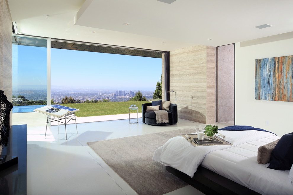 Expansive modern master bedroom in Los Angeles with beige walls, ceramic floors, a ribbon fireplace, a tile fireplace surround and beige floor.