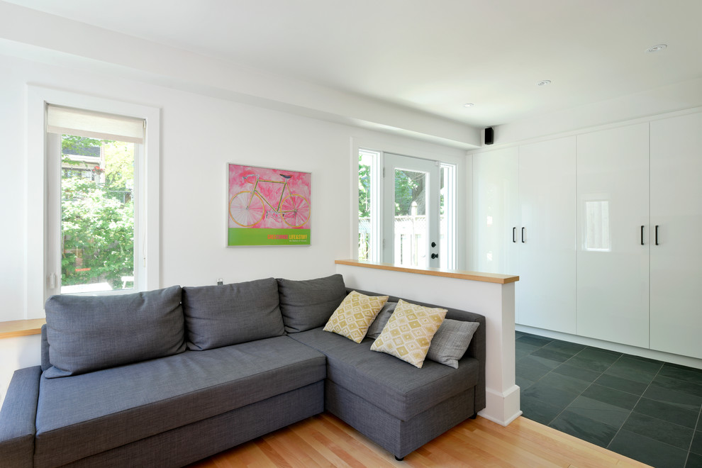 Photo of a mid-sized contemporary gender-neutral kids' playroom in Ottawa with white walls and light hardwood floors.