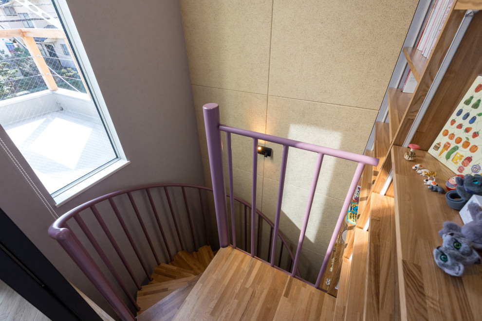 This is an example of a modern wood spiral staircase in Other with open risers, metal railing and wallpaper.