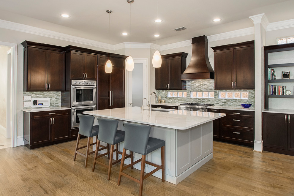 Mid-sized transitional l-shaped medium tone wood floor and brown floor open concept kitchen photo in DC Metro with an undermount sink, recessed-panel cabinets, dark wood cabinets, granite countertops, beige backsplash, ceramic backsplash, stainless steel appliances, an island and beige countertops