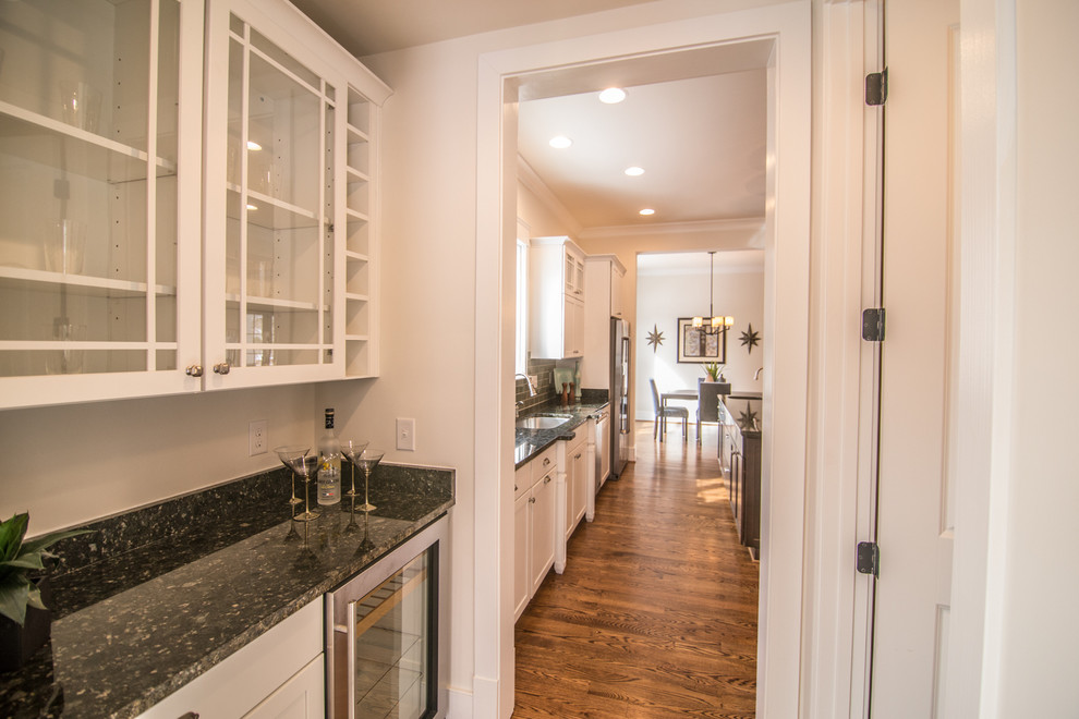 Example of a dark wood floor eat-in kitchen design in DC Metro with an undermount sink, shaker cabinets, granite countertops, stainless steel appliances and an island