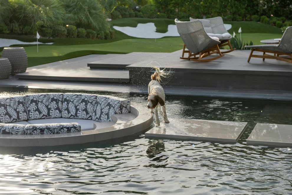 Foto di un'ampia piscina a sfioro infinito moderna personalizzata dietro casa con paesaggistica bordo piscina e piastrelle