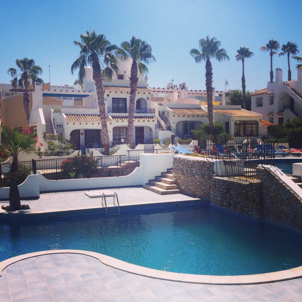 Large contemporary courtyard custom-shaped natural pool in Alicante-Costa Blanca with tile.