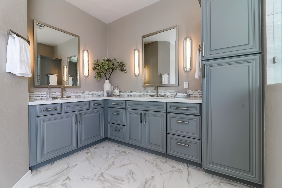 Mid-sized transitional master beige tile and porcelain tile porcelain tile, white floor and double-sink freestanding bathtub photo in Phoenix with raised-panel cabinets, gray cabinets, a two-piece toilet, beige walls, an undermount sink, quartz countertops, a hinged shower door, white countertops and a built-in vanity