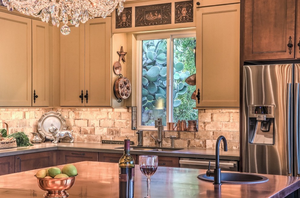 Mid-sized eclectic eat-in kitchen in Phoenix with a single-bowl sink, shaker cabinets, black cabinets, copper benchtops, beige splashback, travertine splashback, stainless steel appliances, porcelain floors, with island and beige floor.
