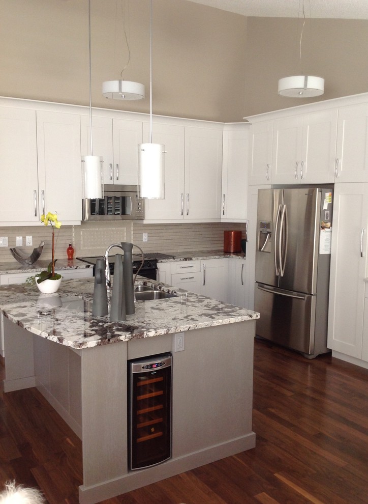 Photo of a mid-sized contemporary u-shaped separate kitchen in Edmonton with a double-bowl sink, shaker cabinets, white cabinets, granite benchtops, beige splashback, ceramic splashback, stainless steel appliances, dark hardwood floors and with island.