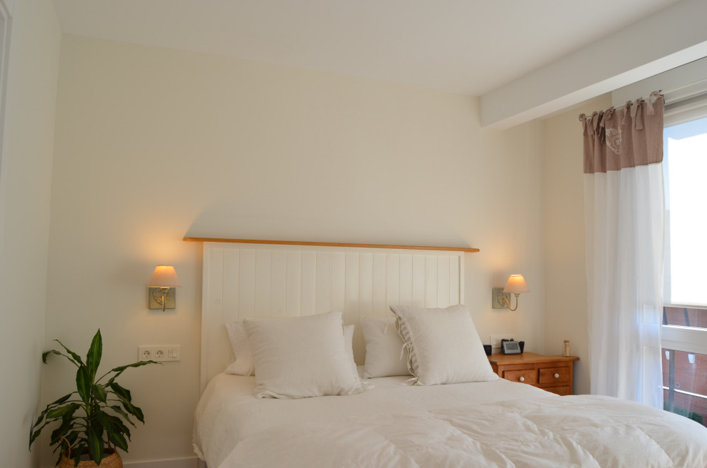Imagen de dormitorio principal y beige y blanco escandinavo de tamaño medio con suelo de madera en tonos medios, suelo marrón y papel pintado