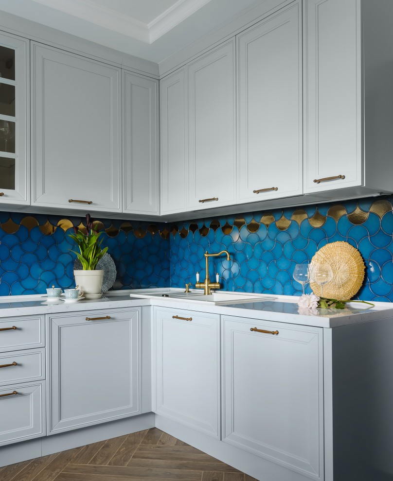 Design ideas for a mid-sized transitional l-shaped separate kitchen in Moscow with a drop-in sink, raised-panel cabinets, turquoise cabinets, quartz benchtops, blue splashback, ceramic splashback, black appliances, porcelain floors, brown floor and white benchtop.