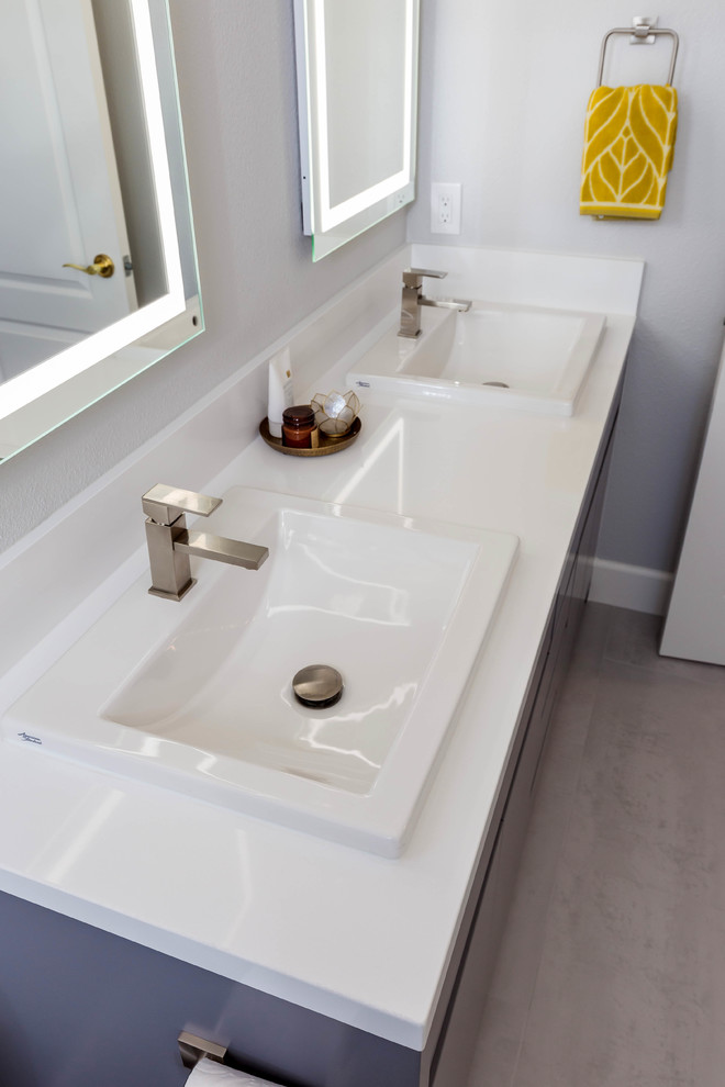 Inspiration for a mid-sized modern kids bathroom in San Francisco with shaker cabinets, grey cabinets, an undermount tub, a shower/bathtub combo, a one-piece toilet, gray tile, ceramic tile, grey walls, porcelain floors, an undermount sink, granite benchtops, grey floor, a sliding shower screen and white benchtops.