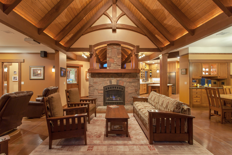 This is an example of a large arts and crafts formal open concept living room in Phoenix with brown walls, concrete floors, a standard fireplace, a stone fireplace surround, no tv and brown floor.